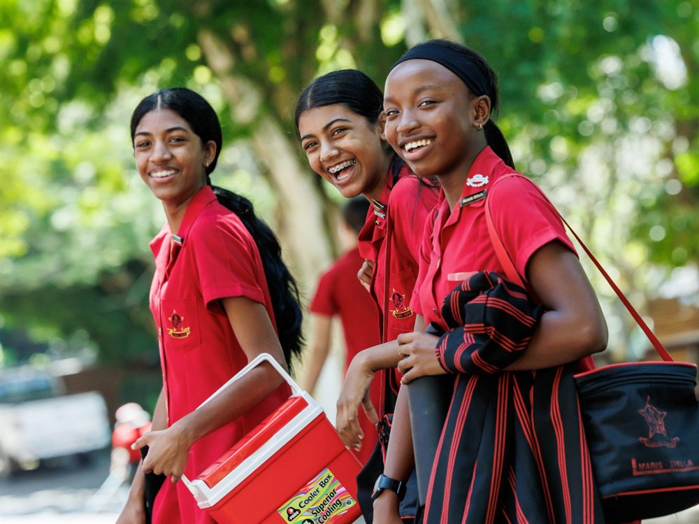 Three High School girls laughing together outdoors